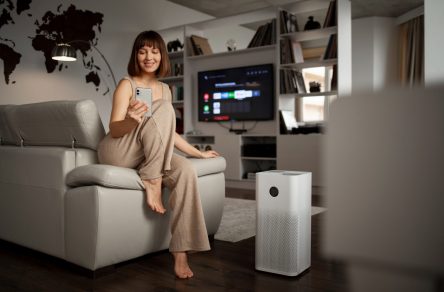 woman using air purifier at home